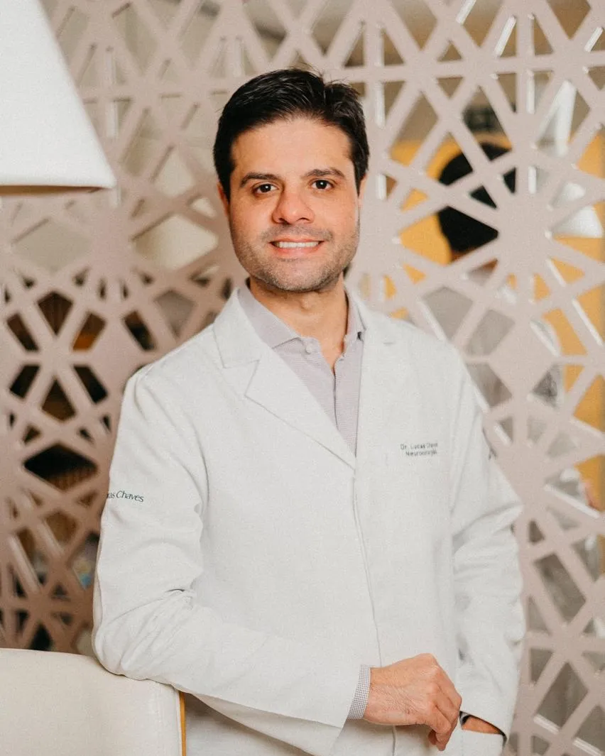 Dr. Lucas Chaves, de jaleco, no consultório
